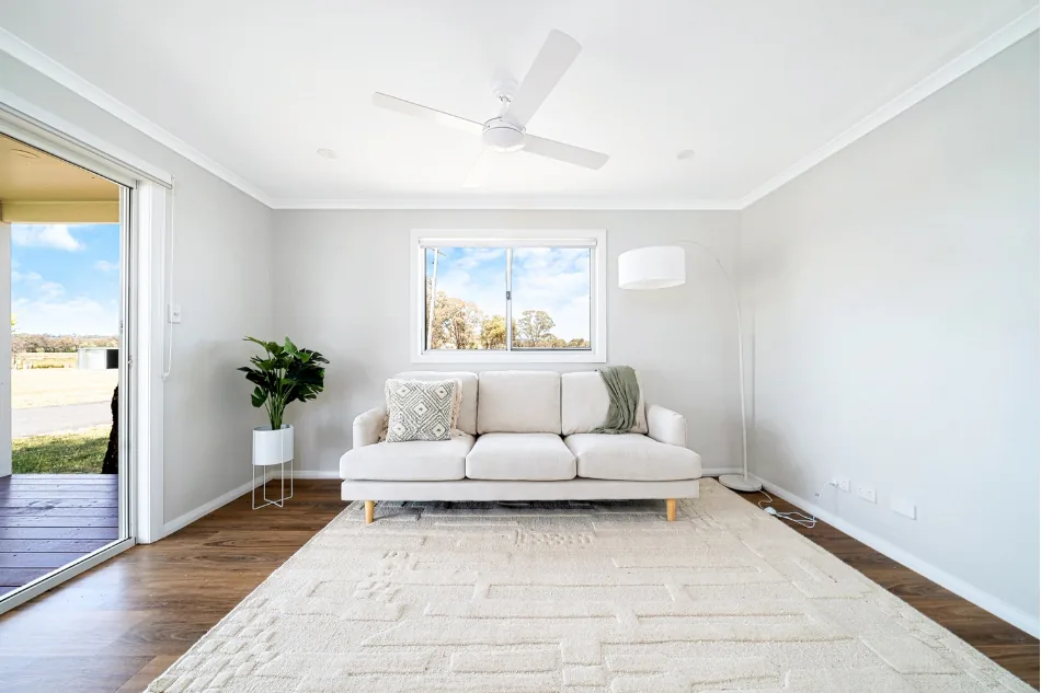 Interior living area of an Aruva modular home showing finished flooring, ceiling fan and rural outlook