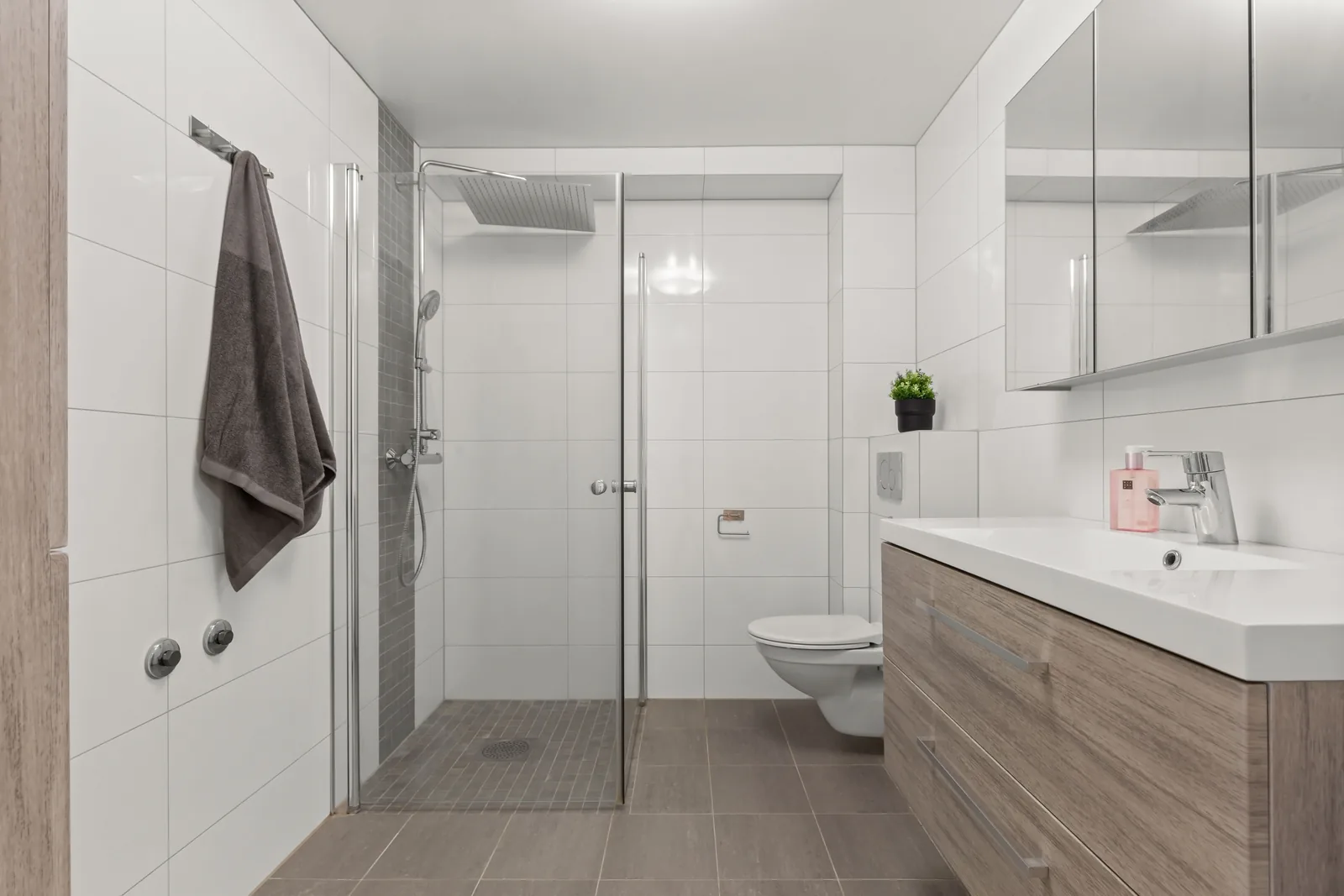 Compact bathroom with shower, vanity and durable easy-care finishes